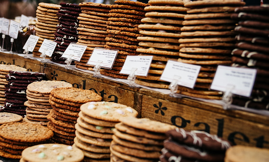 Stacks of assorted cookies at a bakery market stall