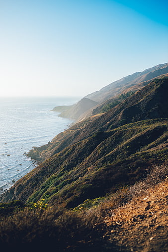 Scenic coastal landscape with rolling hills and ocean view