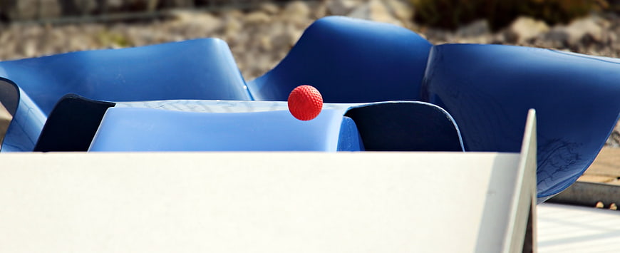 Red Mini Golf Ball On Blue Plastic Course Obstacle