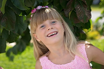 Happy Little Girl with Flower Crown Smiling Outdoors