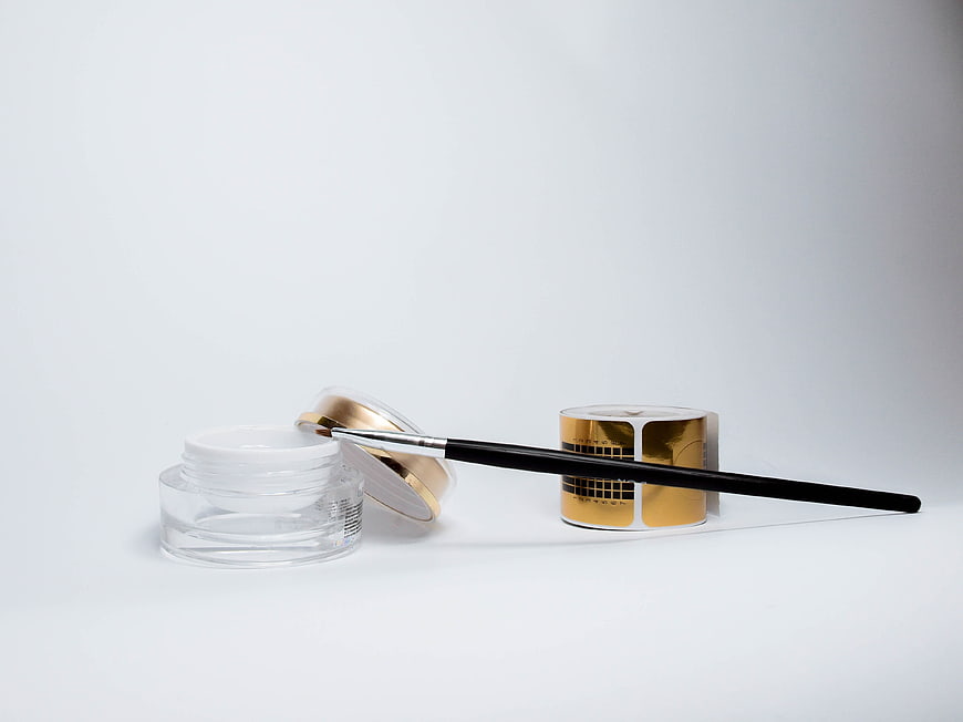Nail Art Brush, Gel Container, and Gold Template on White Background