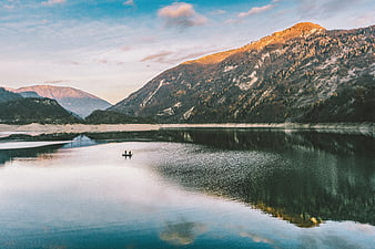 Serene Mountain Lake Landscape with Kayakers at Sunset