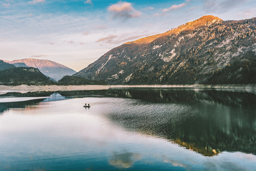 Serene Mountain Lake Landscape with Kayakers at Sunset