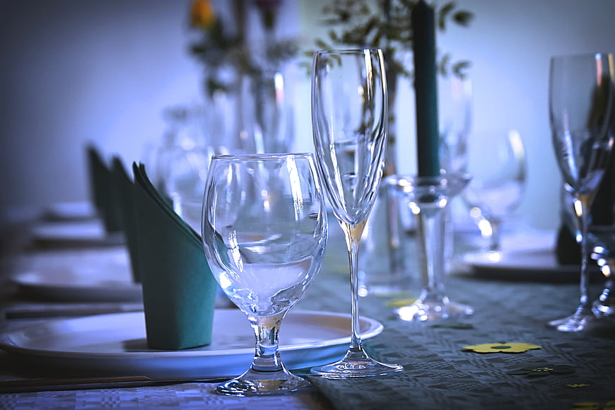 Elegant Banquet Table Setting With Glassware And Green Napkins