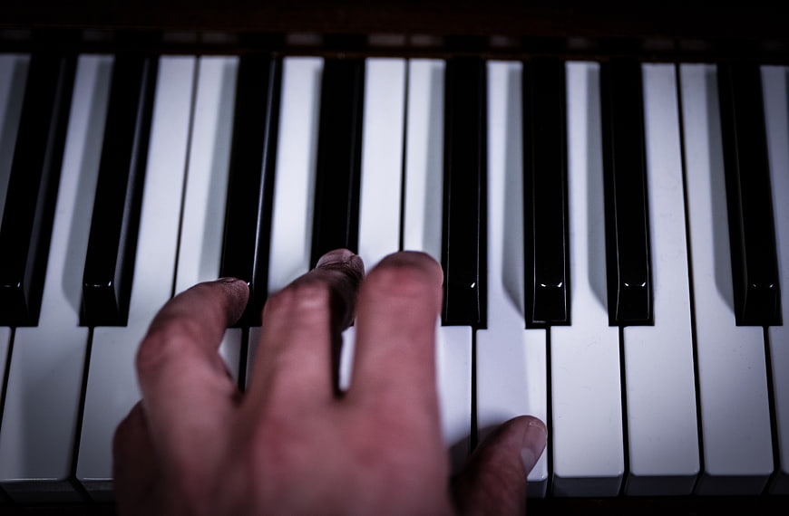 Close-up of hand playing piano keys
