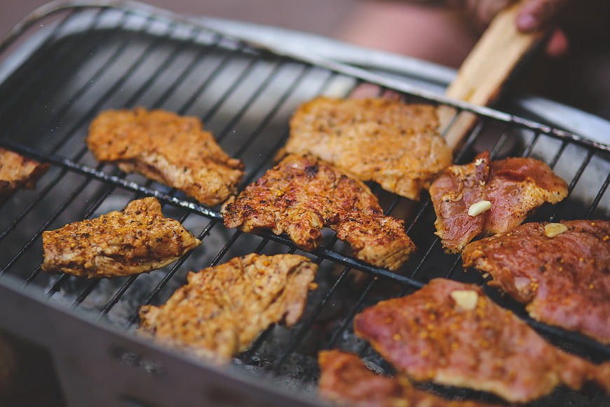 Seasoned Pork Steaks Grilling on Outdoor BBQ Grill