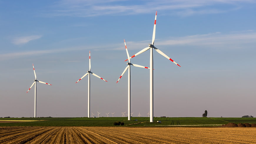 Wind turbines in a green field with blue sky