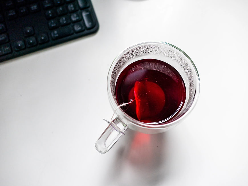 Top View of Red Tea in Glass Cup on White Desk