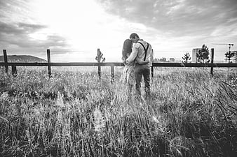 Romantic black and white couple kissing in tall grass field