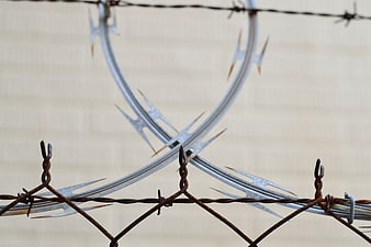 Close-up of rusty barbed wire and razor wire security fence