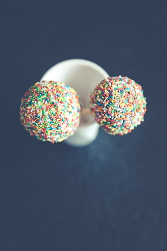 Colorful Cake Pops in White Cup on Blue Background