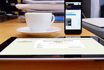 Smartphone and Tablet Displaying Workflow App Next to Coffee Cup