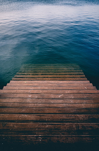 Wooden pier steps leading into calm blue ocean water