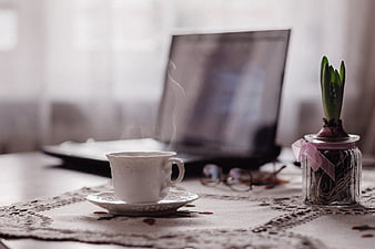 Steaming Coffee Cup and Laptop on Lace Tablecloth