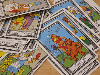 Scattered vintage tarot cards on wooden table