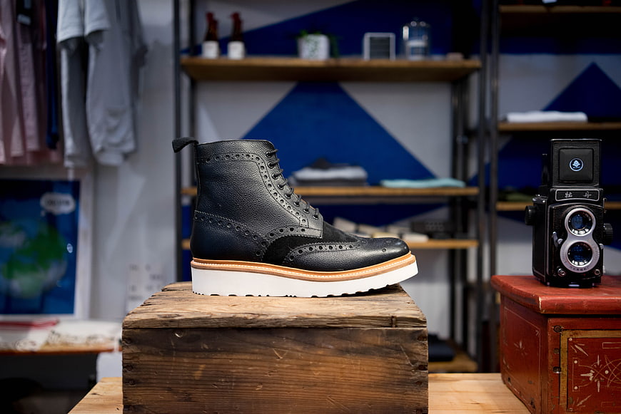 Black Leather Brogue Boot on Wooden Box in Vintage Shop