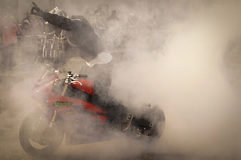 Motorcyclist performing burnout stunt with smoke