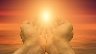 Cupped Hands Reaching Toward Bright Light Against Orange Sunset Sky