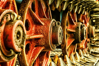 Close-up of rusty red tractor wheels and chain drive mechanism
