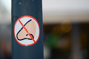 No listening sign sticker on a dark metal pole