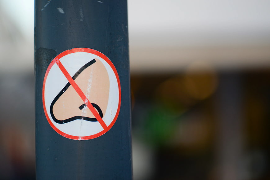 No listening sign sticker on a dark metal pole