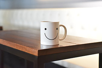 White Ceramic Mug With Smiley Face On Wooden Table