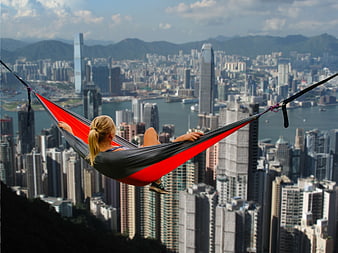 Woman relaxing in hammock overlooking Hong Kong skyline