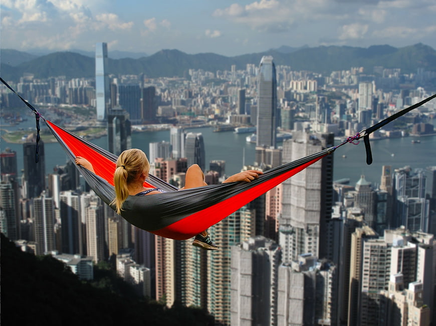 Woman relaxing in hammock overlooking Hong Kong skyline