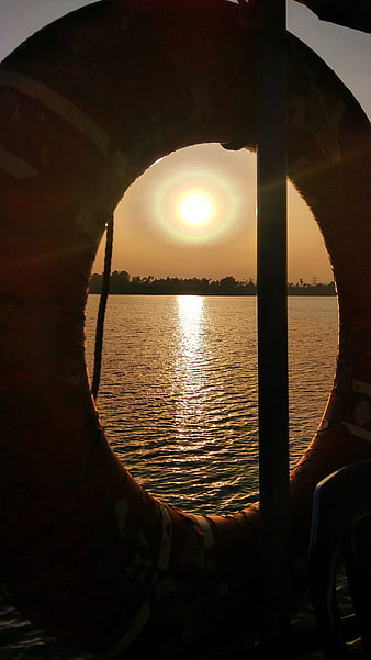 Sunset View Through Silhouetted Lifebuoy on River