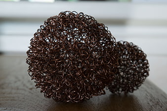Copper Wire Mesh Balls on Wooden Surface