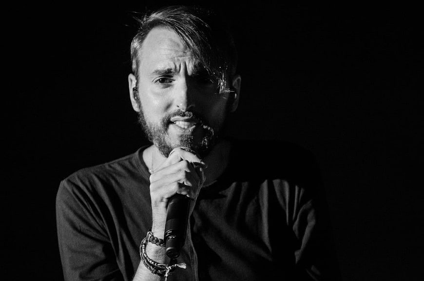 Black and white portrait of male singer holding microphone