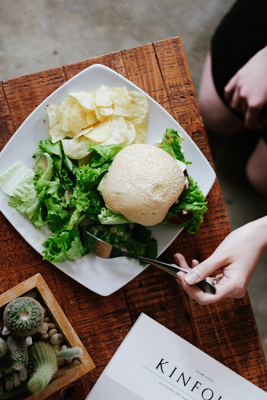 Overhead view of burger and salad on wooden table