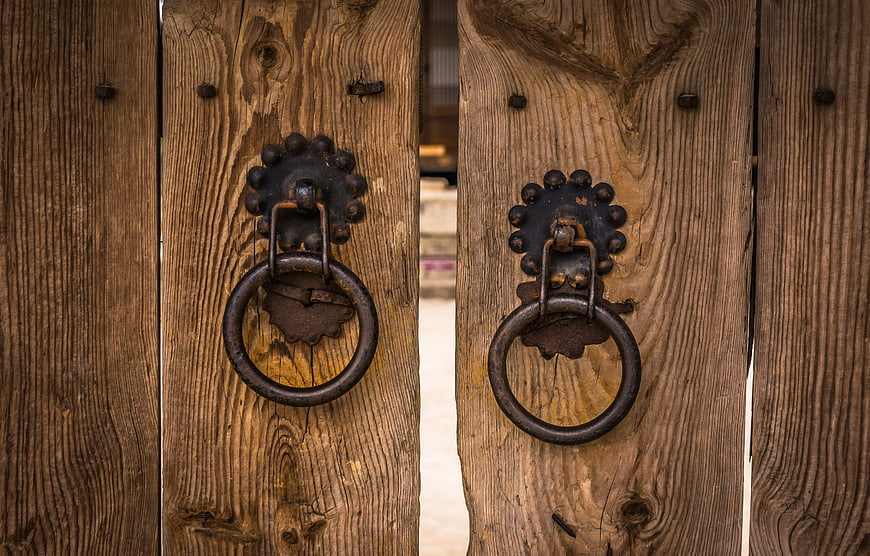 Rusty Iron Door Knobs on Weathered Wooden Gate
