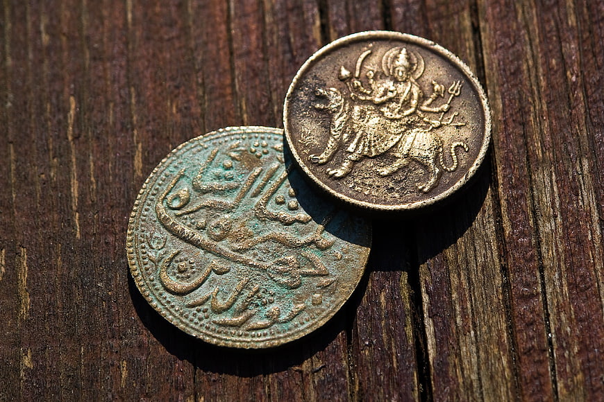 Antique Indian Rupee Coins On Weathered Wooden Surface