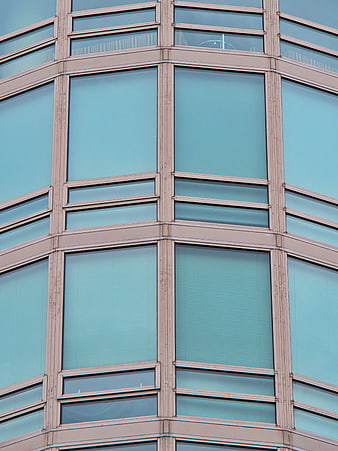 Modern glass office building facade with geometric window pattern