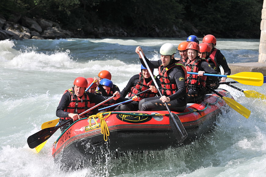 Group of people white water rafting in rapids