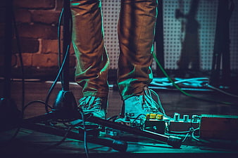 Musician's Feet on Guitar Pedalboard at Night Concert