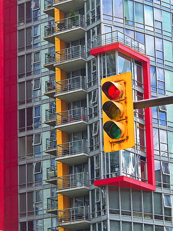 Red Traffic Light Against Colorful Modern Apartment Building