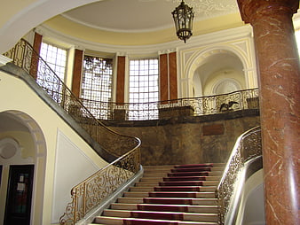Grand marble staircase with ornate iron railings in historic building