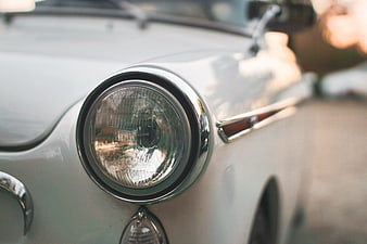 Close-up of vintage white car headlight with chrome details