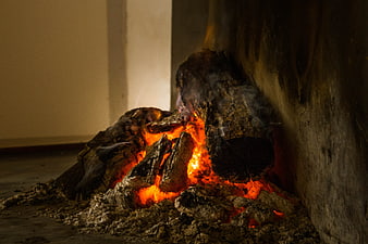 Glowing embers and burning logs in a rustic fireplace