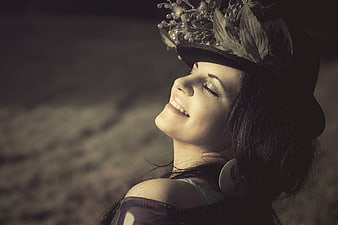 Happy woman wearing floral hat smiling with eyes closed