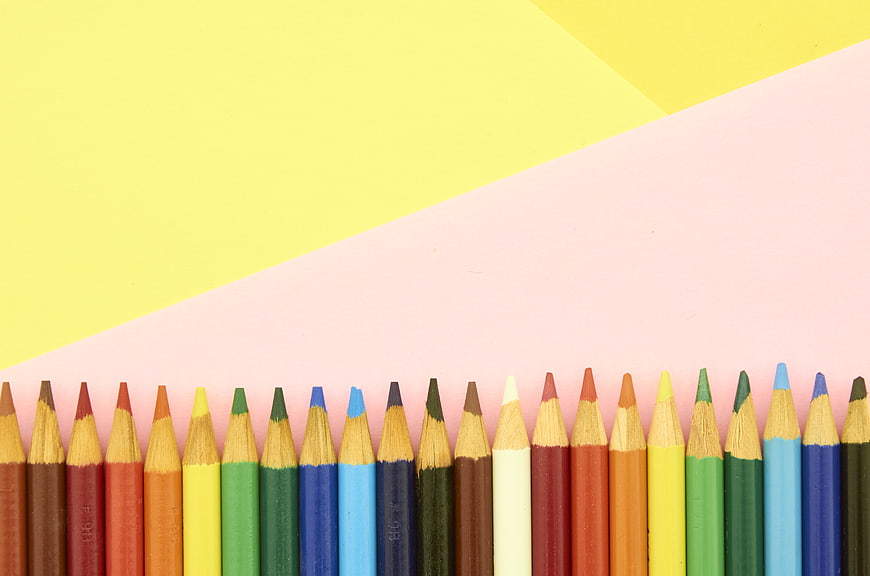 Colorful Pencils on Pastel Yellow and Pink Background