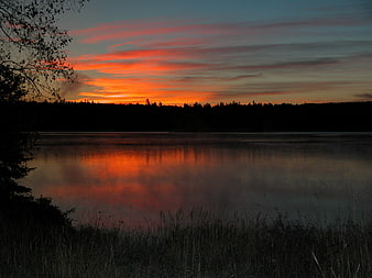 Serene Lake Sunset with Vibrant Orange Sky Reflection
