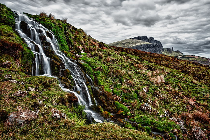 Dramatic waterfall cascading down mossy rocks in Scottish Highlands