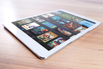 White Tablet on Wooden Table Showing Colorful Media Grid