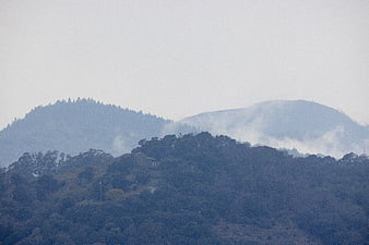 Misty mountain landscape with foggy forest hills