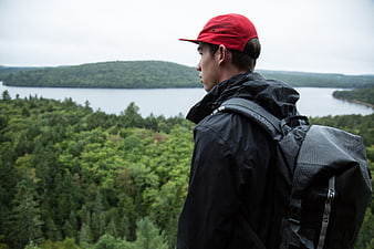 Hiker in Red Cap Overlooking Lake and Forest