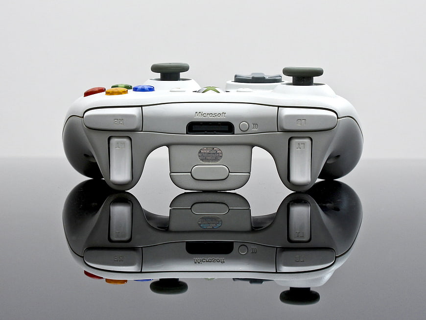 White Xbox 360 Controller on Reflective Surface