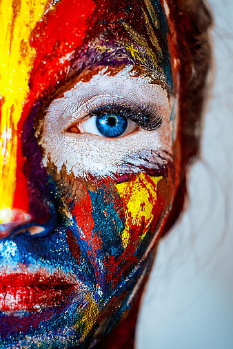 Artistic Close-Up of Woman with Colorful Face Paint and Blue Eye